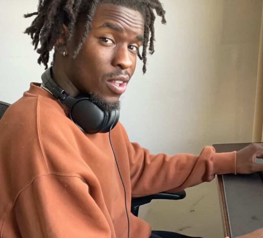 Creator at a desk with headphones around his neck